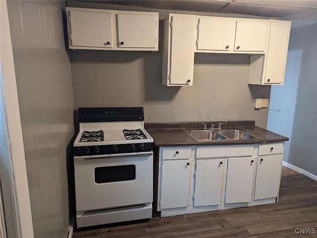 kitchen with a paneled ceiling, sink, white cabinets, dark hardwood / wood-style floors, and white range with gas stovetop