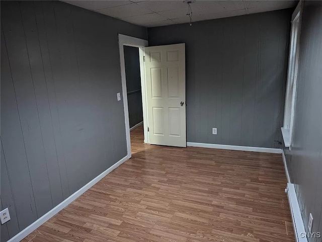 spare room featuring a paneled ceiling and hardwood / wood-style flooring