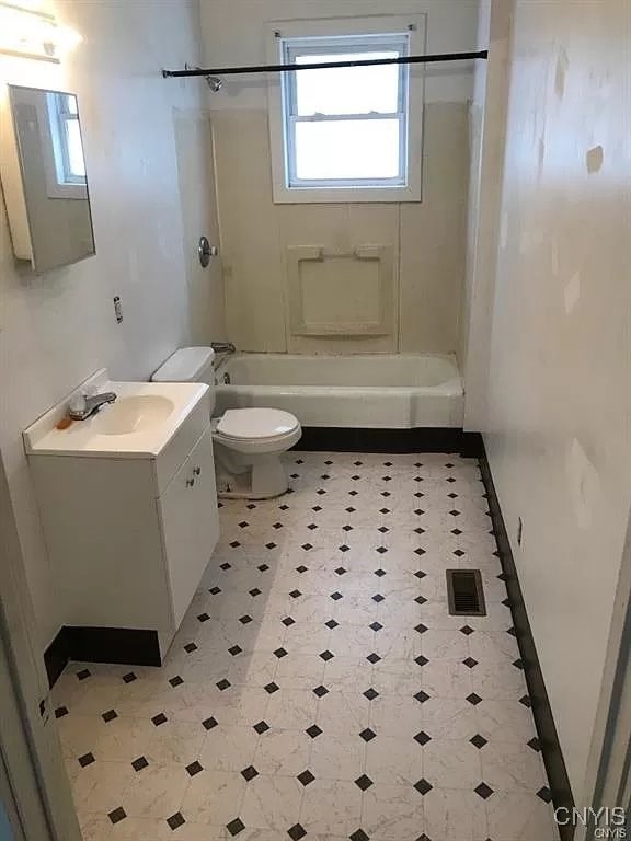 full bathroom with washtub / shower combination, toilet, vanity, and tile patterned flooring