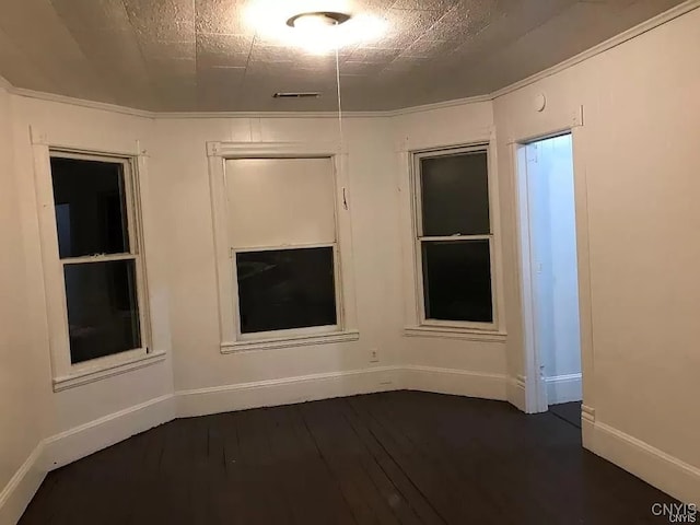 unfurnished room with ornamental molding and dark hardwood / wood-style flooring