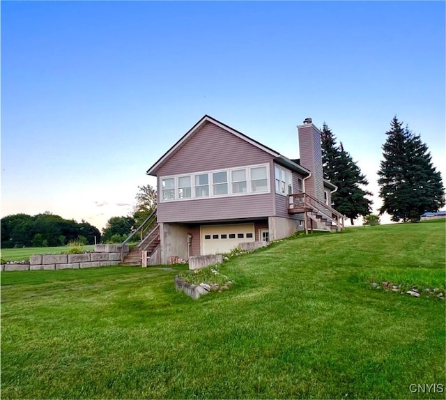 back of house with a garage and a yard