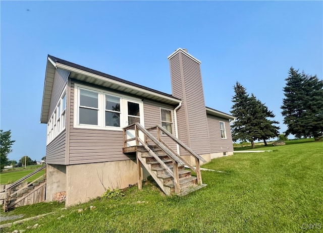 back of property featuring a lawn