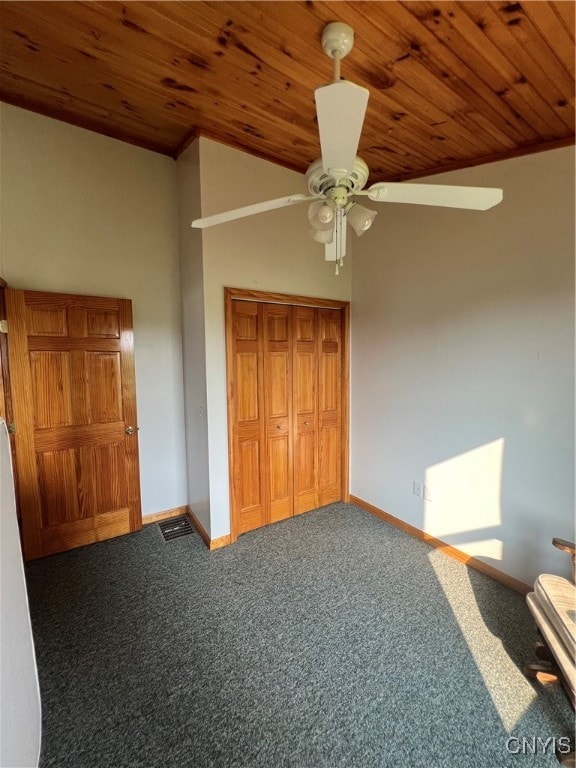 unfurnished bedroom featuring high vaulted ceiling, a closet, carpet floors, ceiling fan, and wood ceiling