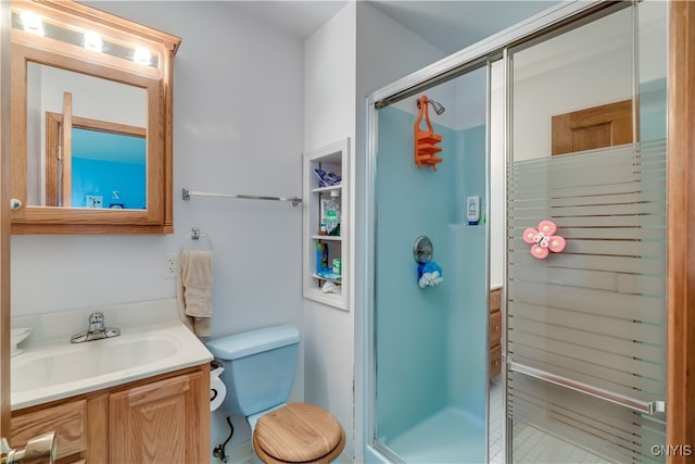 bathroom featuring toilet, vanity, and an enclosed shower