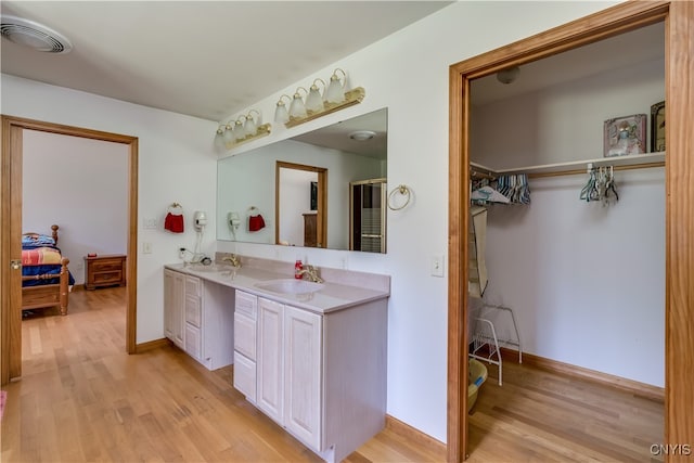 bathroom with double sink vanity and hardwood / wood-style flooring