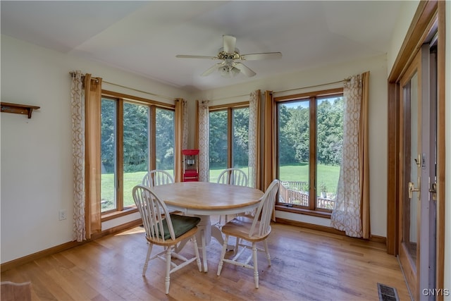 dining room featuring ceiling fan, light wood-type flooring, and a healthy amount of sunlight