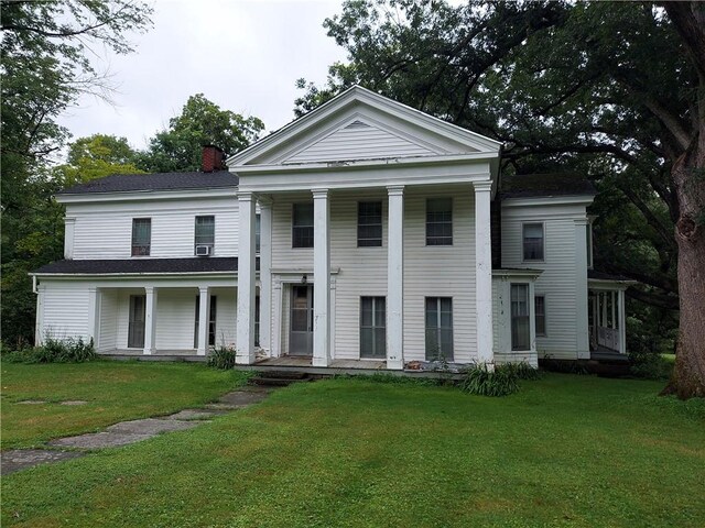 neoclassical / greek revival house featuring a front lawn