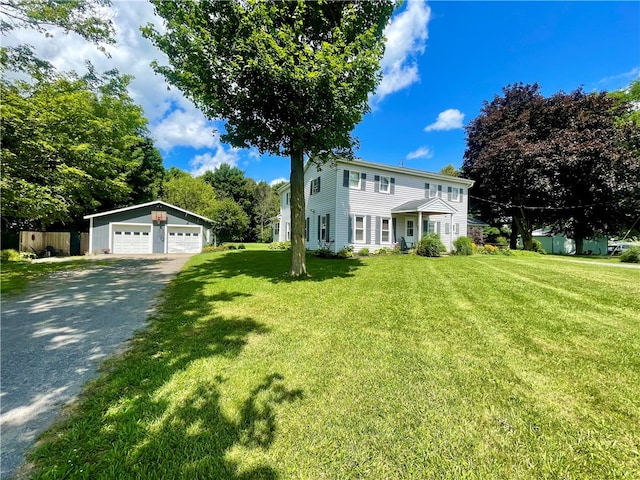 view of front of house featuring a garage, an outbuilding, and a front yard