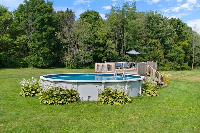 view of pool featuring a wooden deck and a lawn