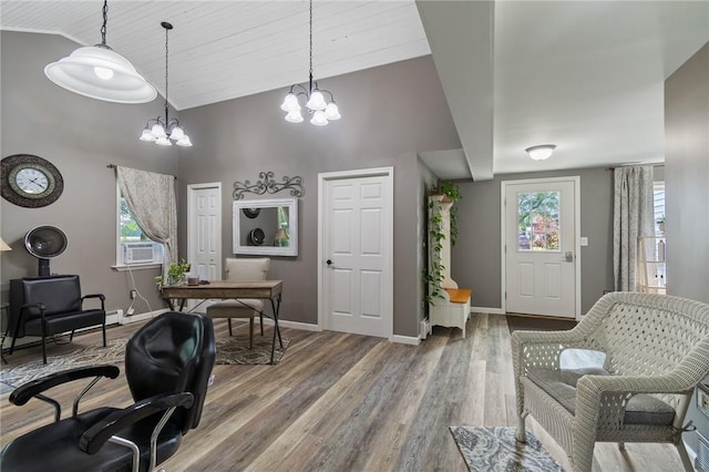 office space featuring cooling unit, wood-type flooring, a chandelier, and high vaulted ceiling