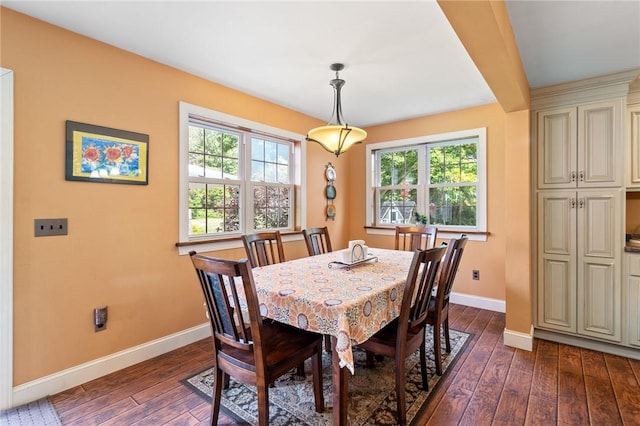 dining space featuring dark hardwood / wood-style floors and beam ceiling