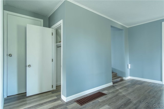 empty room featuring crown molding and light wood-type flooring