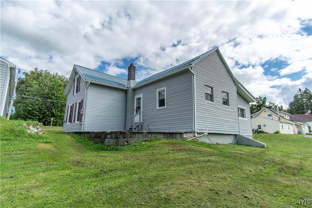 rear view of property featuring a lawn