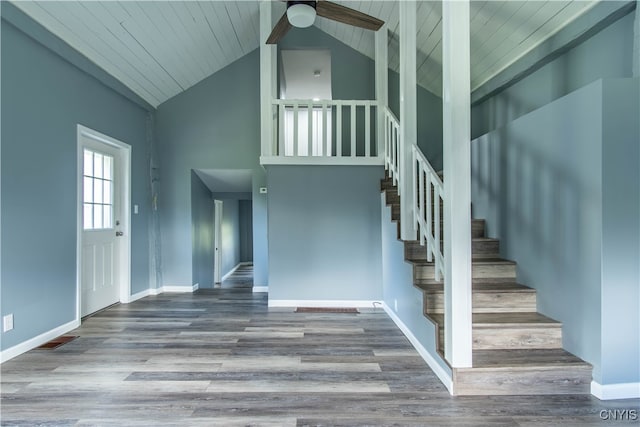 stairway with ceiling fan, high vaulted ceiling, wooden ceiling, and wood-type flooring