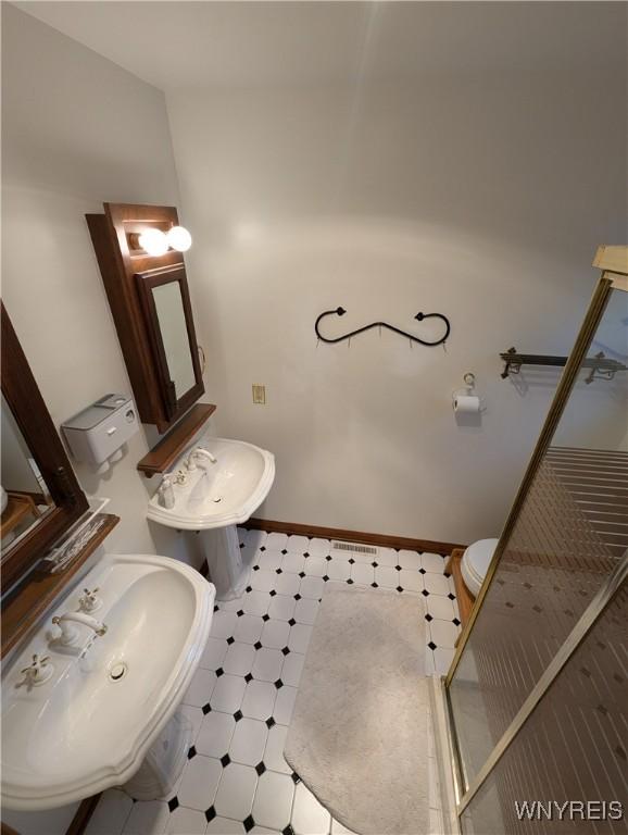bathroom featuring a sink, tile patterned floors, and baseboards