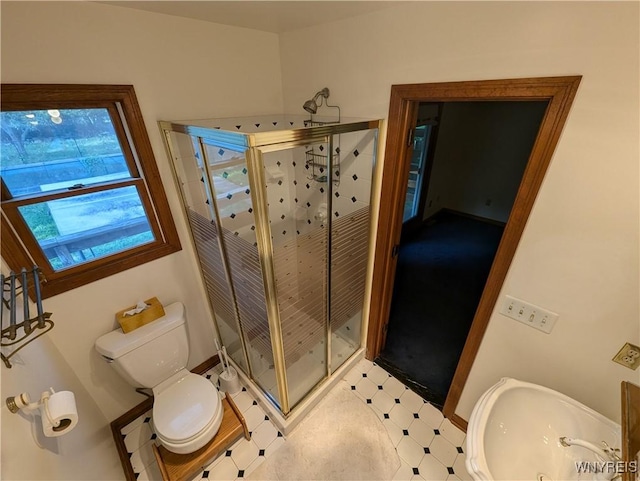 bathroom featuring a stall shower, tile patterned floors, and toilet