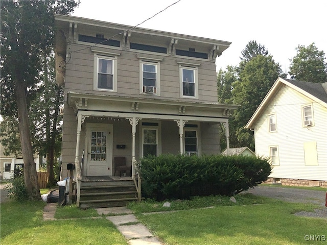 italianate-style house with a front yard and a porch