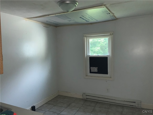 tiled empty room with a baseboard radiator