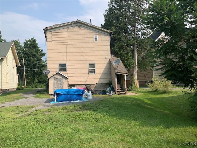 rear view of property featuring a yard