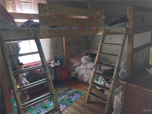 bedroom with hardwood / wood-style flooring and multiple windows