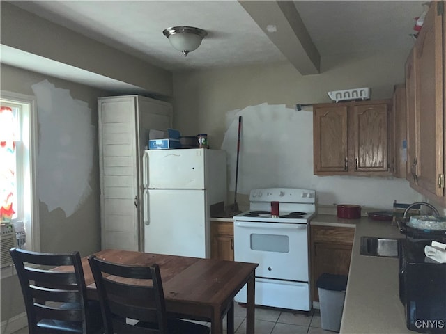 kitchen with light tile patterned floors, sink, and white appliances