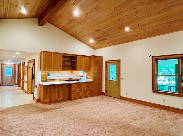 kitchen featuring light carpet, a healthy amount of sunlight, and beam ceiling