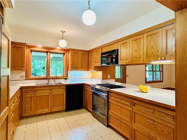 kitchen featuring kitchen peninsula, black appliances, decorative light fixtures, and sink