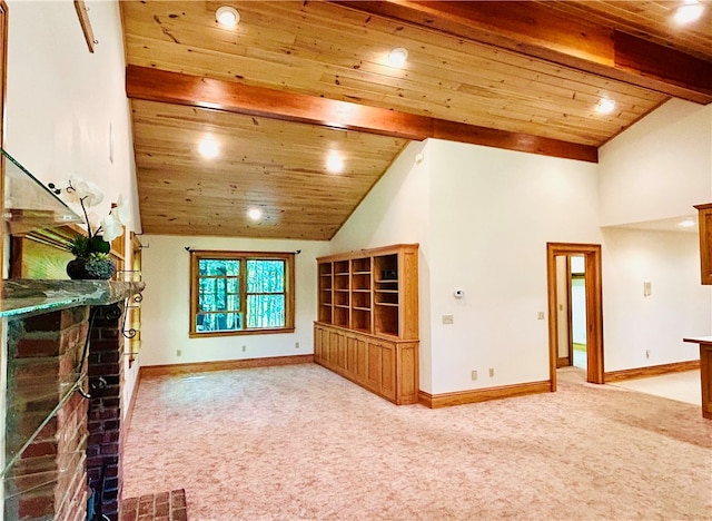 unfurnished living room featuring high vaulted ceiling, wooden ceiling, a fireplace, beam ceiling, and light colored carpet