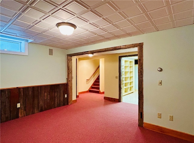 basement featuring wood walls and carpet