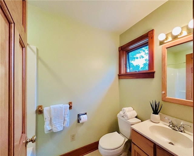 bathroom with walk in shower, vanity, and toilet