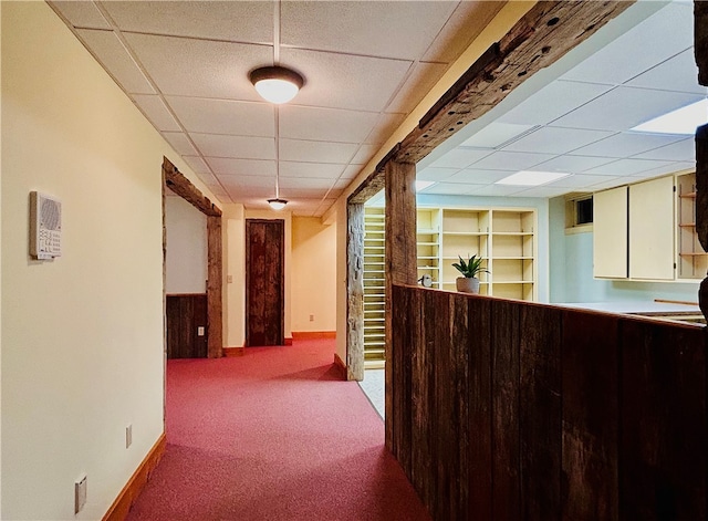 hall featuring light colored carpet and a paneled ceiling