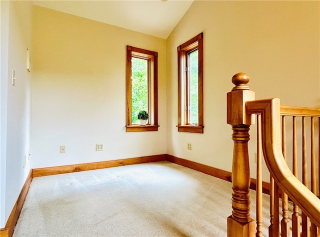 carpeted spare room with lofted ceiling