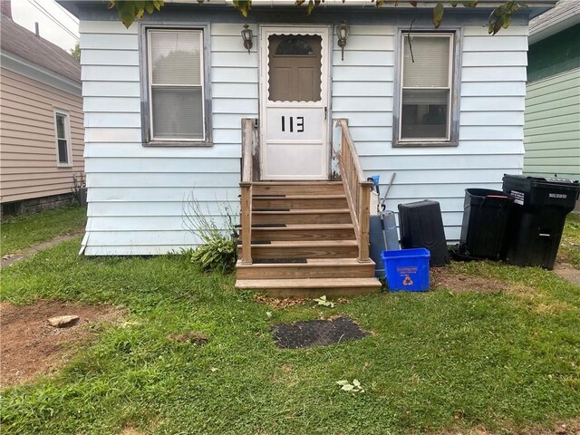 doorway to property featuring a lawn