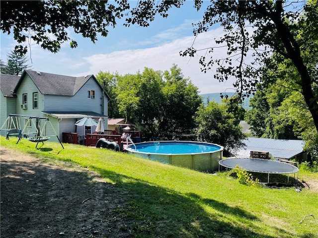 view of swimming pool with a deck and a lawn