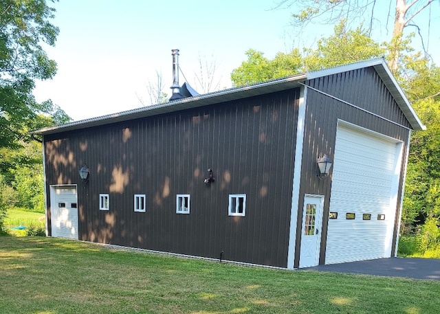 view of side of property featuring a lawn, an outdoor structure, and a garage