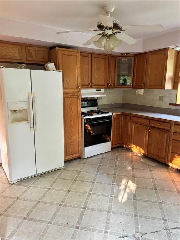 1356 Terry Clove Rd, Hamden, NY 13752 - kitchen with white appliances, under cabinet range hood, brown cabinets, ceiling fan, and glass insert cabinets