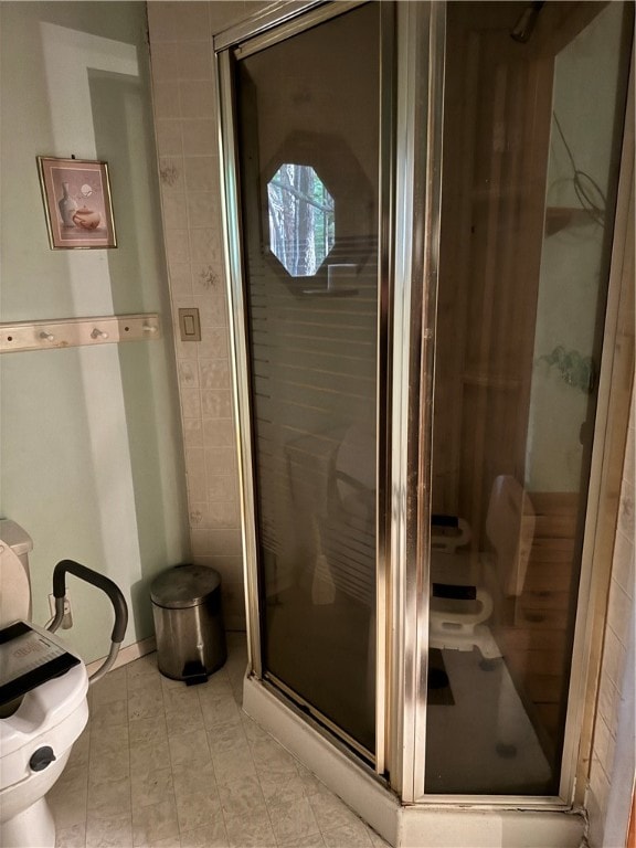 bathroom featuring an enclosed shower, toilet, and tile patterned floors