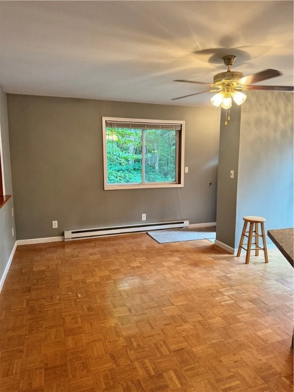 spare room with ceiling fan, parquet floors, and baseboard heating