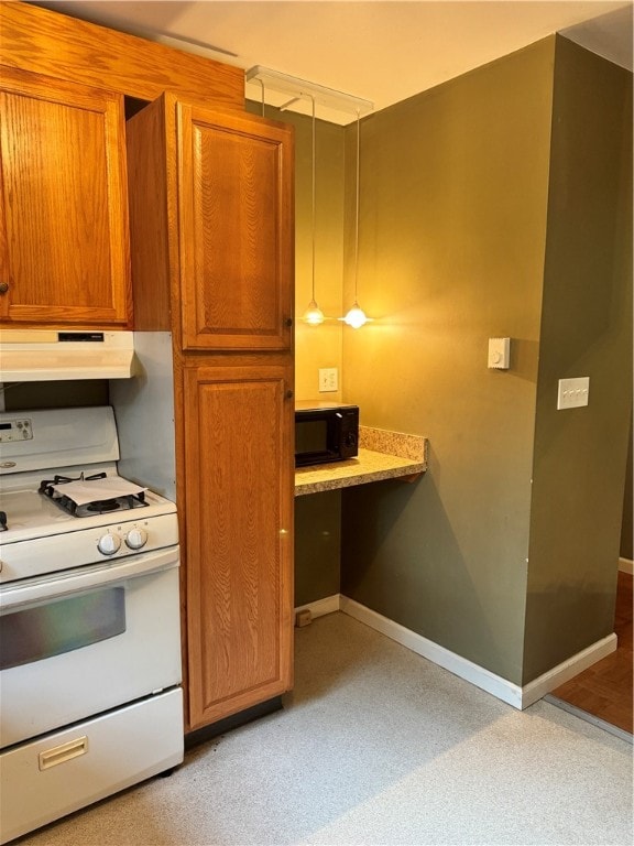 kitchen featuring white range with gas stovetop and built in desk