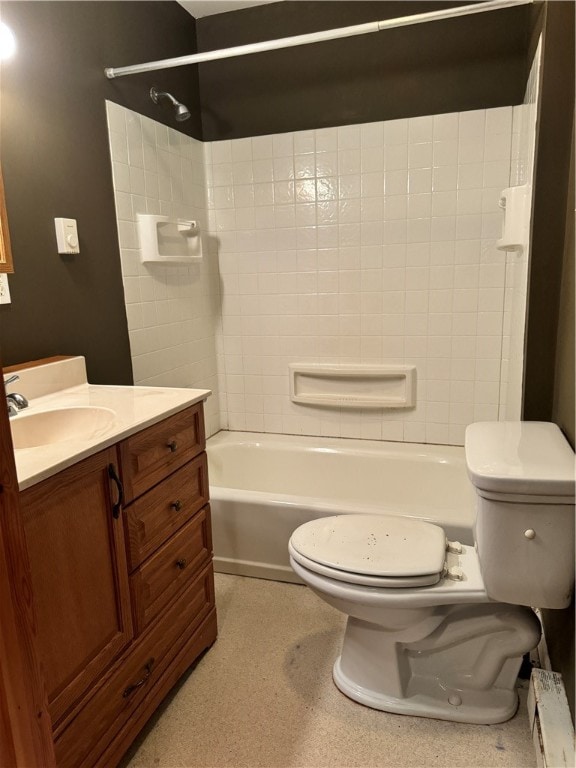 full bathroom with tiled shower / bath, baseboard heating, vanity, and toilet