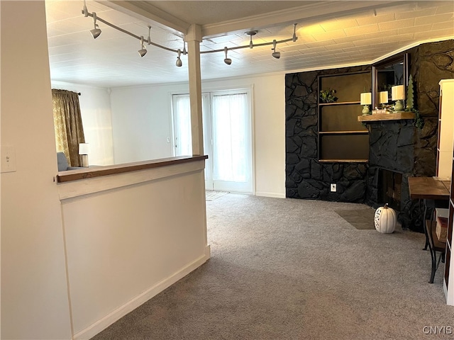 carpeted living room with track lighting and ornamental molding