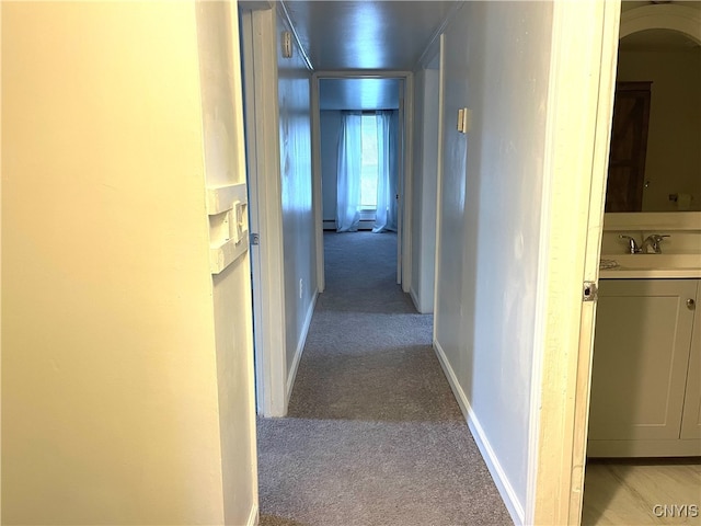 corridor with light colored carpet and sink