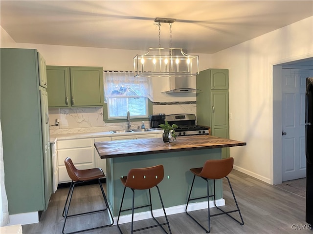 kitchen with a breakfast bar, gas stove, dark hardwood / wood-style floors, and wooden counters