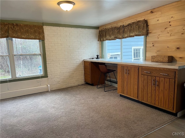 kitchen featuring light carpet, brick wall, and a baseboard heating unit