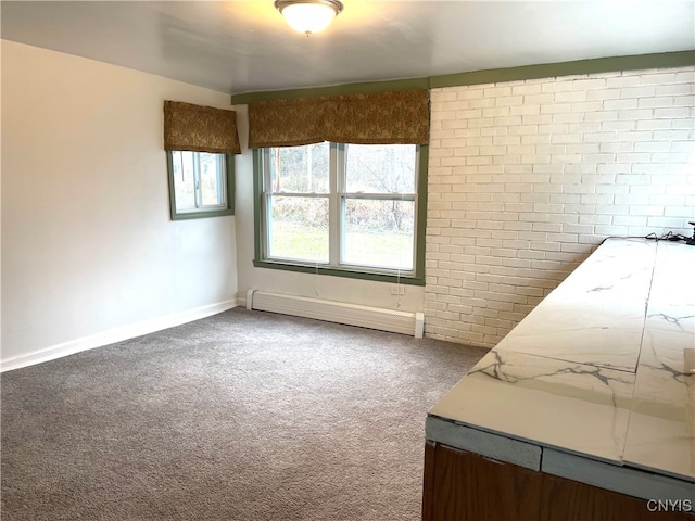 empty room featuring carpet, brick wall, and a baseboard heating unit