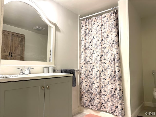 bathroom with walk in shower, vanity, and toilet