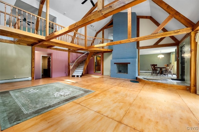 unfurnished living room with hardwood / wood-style flooring, high vaulted ceiling, a multi sided fireplace, and a baseboard radiator