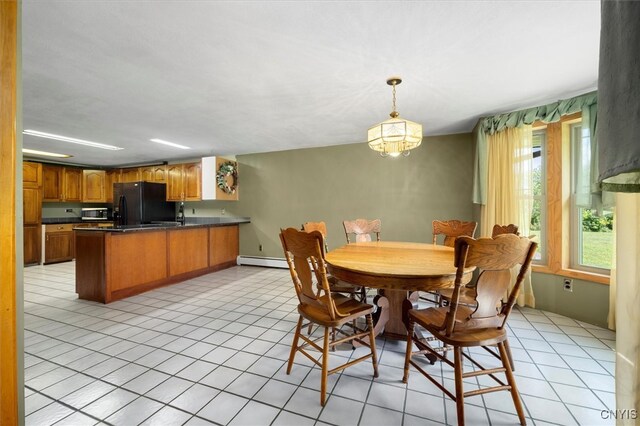 dining space with light tile patterned floors, a baseboard heating unit, and an inviting chandelier