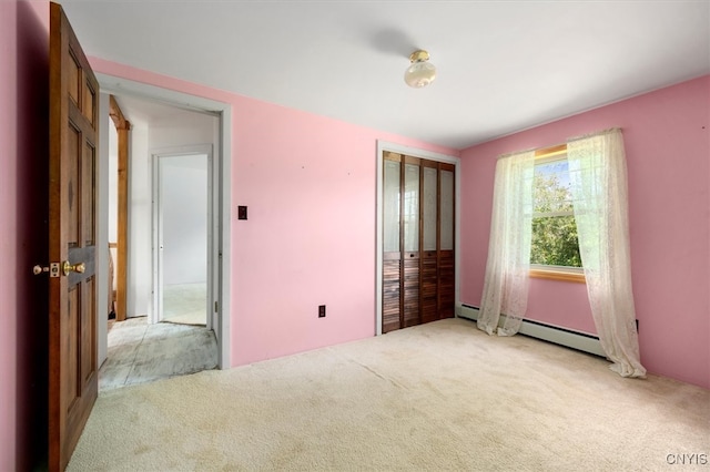 unfurnished bedroom with light carpet, a closet, and baseboard heating