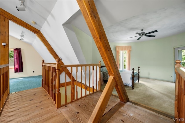 staircase featuring ceiling fan, plenty of natural light, and hardwood / wood-style floors